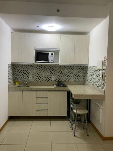 a kitchen with a counter and a microwave at Top Flat confortavel e muito bem localizado in Brasília