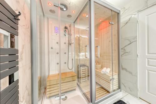 a walk in shower in a bathroom with glassdoors at Suite Love Hammam et Sauna in Les Pavillons-sous-Bois