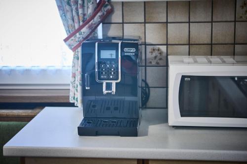 a phone sitting on a counter next to a microwave at Hotel Garni Tirol in Walchsee