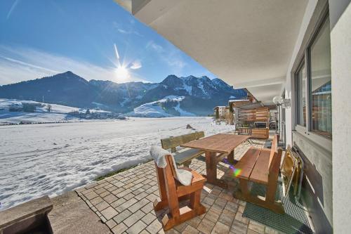 a table and chairs on a patio with a view of the mountains at Hotel Garni Tirol in Walchsee