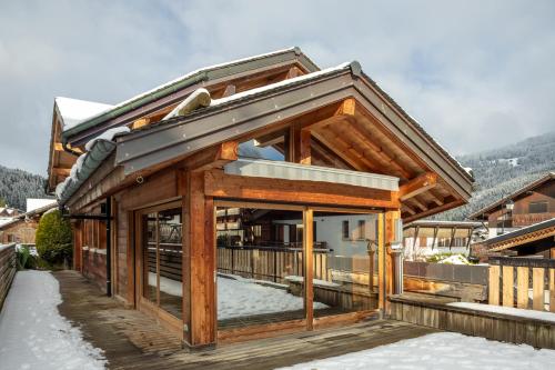une maison en bois avec un balcon dans la neige dans l'établissement Simply Morzine - Chalet Visage, à Morzine