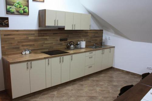 a kitchen with white cabinets and a wooden counter top at Wellness Hotel Zavadilka in Prostřední Bečva