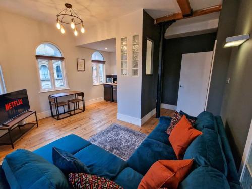 a living room with a blue couch and a kitchen at City Centre Manchester Apt by City SuperHost in Manchester