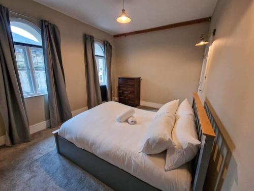 a bedroom with a bed with white sheets and pillows at City Centre Manchester Apt by City SuperHost in Manchester