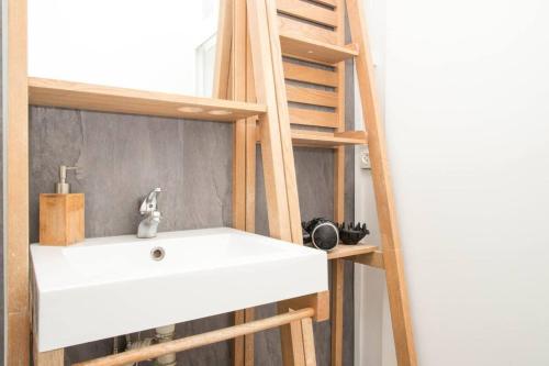 La salle de bains est pourvue d'un lavabo blanc et d'une échelle. dans l'établissement Appartement Ancien - 4 chambres - Centre ville Poitiers, à Poitiers