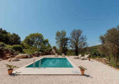 una piscina in mezzo a un cortile di ghiaia di Villa Magic Stone a Šišići