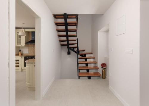 Una escalera en una cocina con paredes blancas. en Villa Magic Stone, en Šišići
