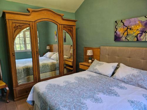 ein Schlafzimmer mit zwei Betten und einem großen Spiegel in der Unterkunft Luna Roja , reserva natural, La granja,Sierras chicas in La Granja