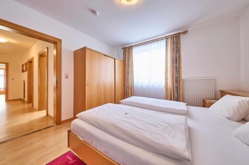 a bedroom with two white beds and a window at Hotel Garni Tirol in Walchsee