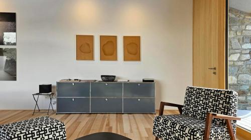 a living room with a blue cabinet and two chairs at Vergalderie in Gargellen