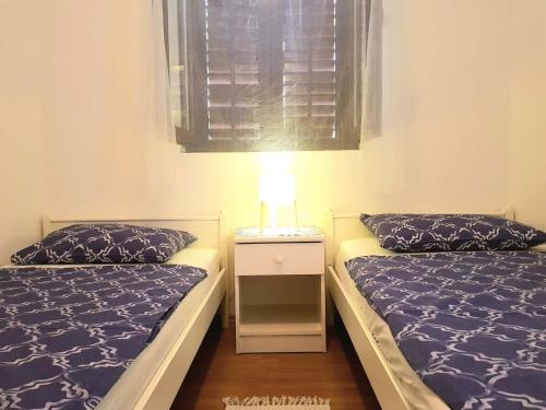 a bedroom with two beds and a lamp on a night stand at Apartments Mare in Mandre