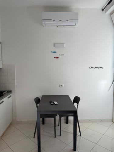a black table and two chairs in a kitchen at Camere Margot in Monterosso al Mare