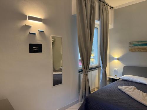 a bedroom with a bed and a mirror on the wall at Camere Margot in Monterosso al Mare
