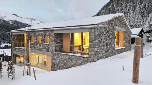 a stone house in the snow in the mountains at Vergalderie in Gargellen