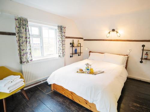 a bedroom with a bed with a tray of food on it at Prospect Place by The Suffolk Cottage Collection in Westleton