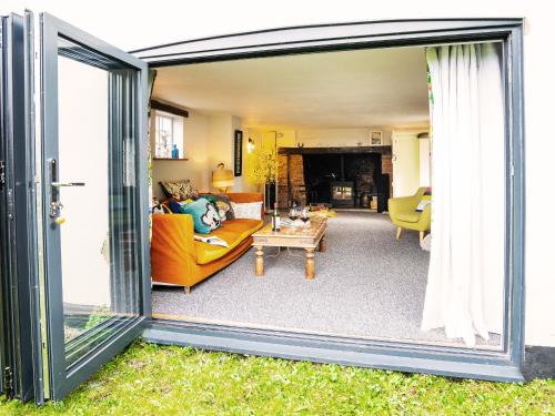 a living room with a sliding glass door and a couch at Prospect Place by The Suffolk Cottage Collection in Westleton