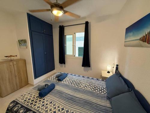a bedroom with a large bed with blue pillows on it at Apartamento con piscina - Posta de sol in Cala en Forcat