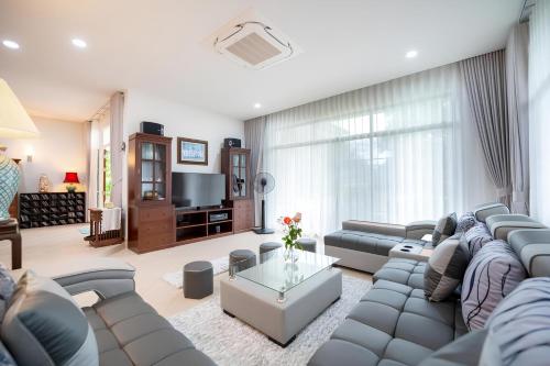 a large living room with a couch and a tv at Sriwaree Pool Villa Khao Lak - 8 meters pool - 3 bedroom - 2 bath in Khao Lak