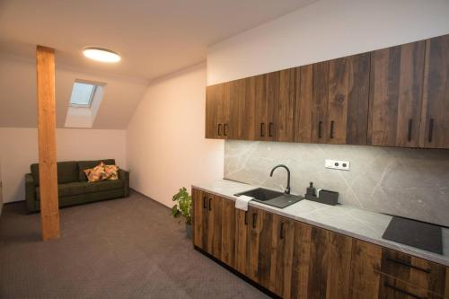a kitchen with a sink and a couch in a room at Wellness Hotel Zavadilka in Prostřední Bečva