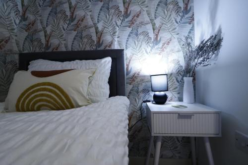 a bedroom with a bed and a night stand with a lamp at listing SALE - Entire Town Centre Apartment Free Parking WiFi in Colchester