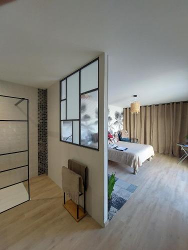 une chambre avec un lit et un grand miroir dans l'établissement Villa récente spacieuse piscine St Gilles, à Saint-Gilles-Croix-de-Vie