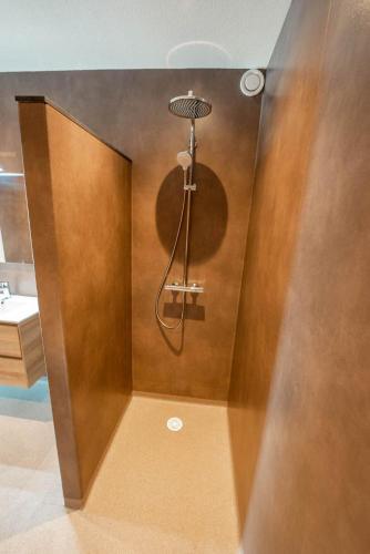 a bathroom with a shower in the corner of a room at Appartementen De Witte Brugh in Buren