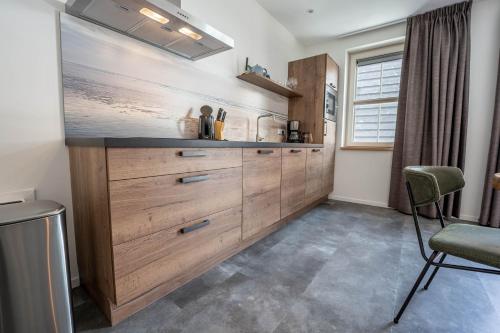 a kitchen with wooden cabinets and a counter top at Appartementen De Witte Brugh in Buren