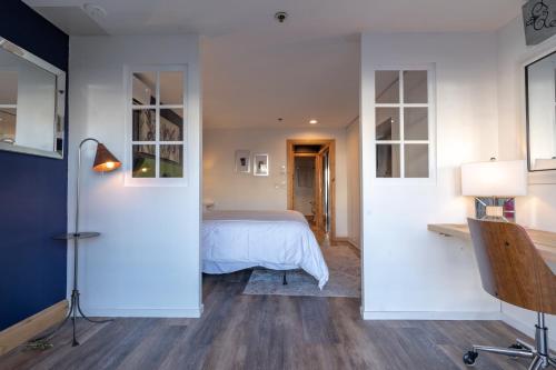 a bedroom with a bed with white walls and wooden floors at Treasure Mountain Inn in Park City