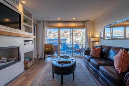 a living room with a leather couch and a fireplace at Treasure Mountain Inn in Park City