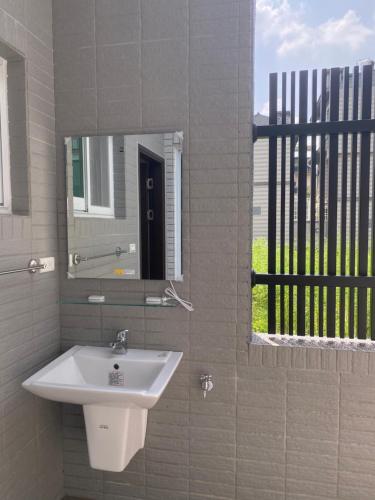 a bathroom with a sink and a mirror and a window at Orange Homestay in Meinong