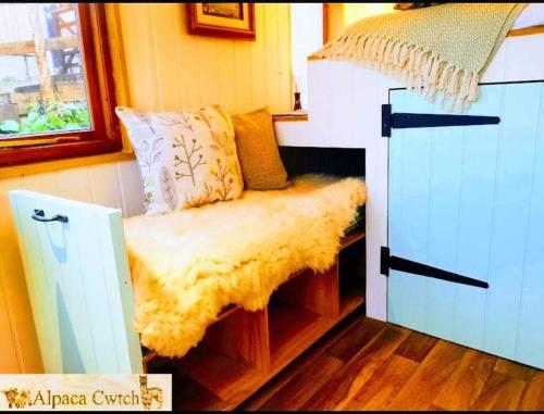 a small room with a couch with a window at Alpaca Cwtch - Pembrokeshire, West Wales in Fishguard