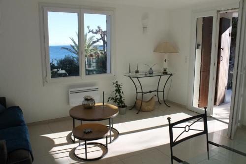 - un salon avec une table et une vue sur l'océan dans l'établissement Joli t3 face mer, aux Issambres