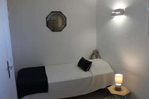 - une chambre dotée d'un lit avec une horloge murale dans l'établissement Joli t3 face mer, aux Issambres