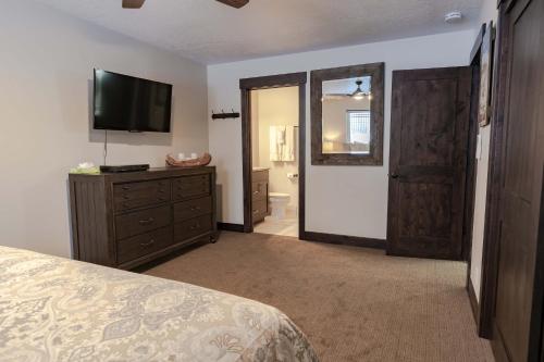 a bedroom with a bed and a dresser with a television at Treasure Mountain Inn in Park City