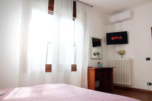 a bedroom with a bed with white curtains and a desk at The Ngatchou in Venice