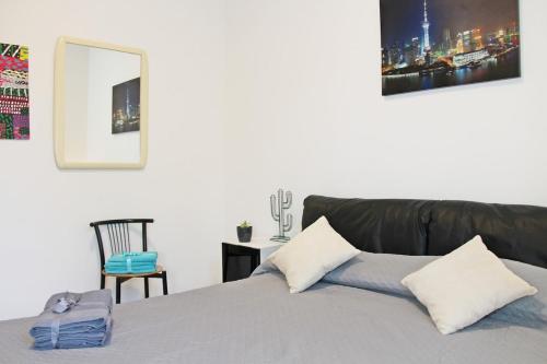 a bedroom with a bed and a chair and a mirror at The Ngatchou in Venice