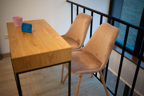 a wooden table with two chairs and a laptop on it at EcoTravel New in Suceava