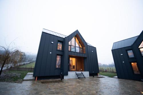 a black house with two black containers at EcoTravel New in Suceava