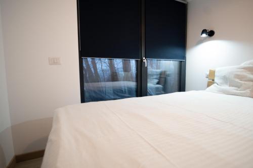 a bedroom with a white bed and a window at EcoTravel New in Suceava