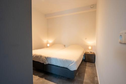 a bedroom with a bed and two lights on the wall at Appartementen De Witte Brugh in Buren