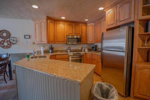 a kitchen with wooden cabinets and a stainless steel refrigerator at Treasure Mountain Inn in Park City