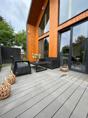 a wooden deck with a table and chairs on a house at Stodoła w Trelkówku in Szczytno