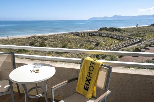 a table and chairs with a view of the beach at Eix Platja Daurada Hotel & SPA in Can Picafort