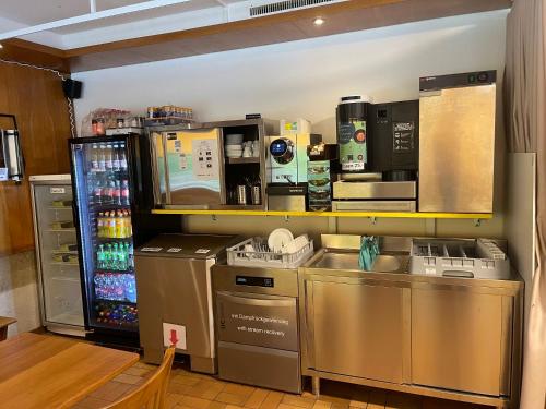 a coffee shop with a counter and a refrigerator at Long & Short Stay Hotel Bahnhof Ausserberg in Ausserberg