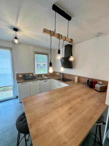 a kitchen with a wooden table in a room at La Villa Chill in Port-en-Bessin-Huppain