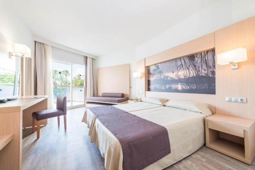 pokój hotelowy z dużym łóżkiem i biurkiem w obiekcie Eix Lagotel Holiday Resort w Playa de Muro