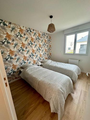 two beds in a bedroom with a wall at La Villa Chill in Port-en-Bessin-Huppain