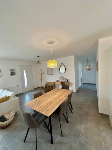 a dining room with a wooden table and chairs at La Villa Chill in Port-en-Bessin-Huppain