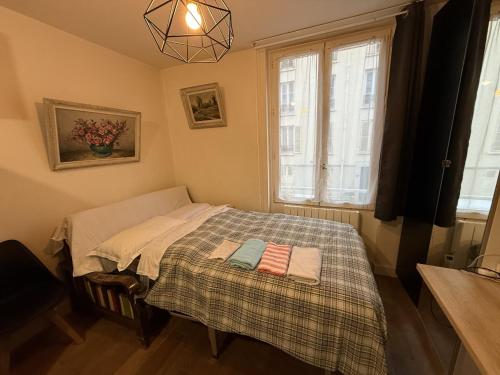 une petite chambre avec un lit et une fenêtre dans l'établissement Studio Chic proche de la tour Eiffel, à Paris