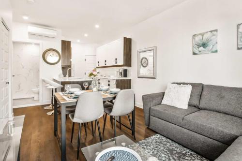 a living room and kitchen with a couch and a table at Le Mile End by M11 - Upscale 1 BDR with Sofa Bed in Montréal